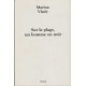 Sur la plage un homme en noir